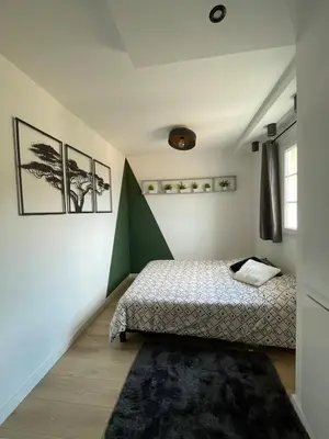 a bedroom with a bed and a green accent wall at Appartement neuf avec vue in Mallemort