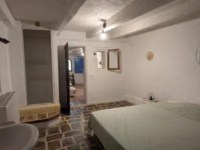 a bedroom with a bed and a bathroom with a sink at La Bergerie de Lorette - Au Cœur du Luberon in Bonnieux