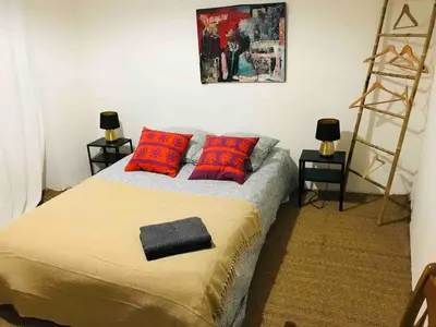 a bedroom with a bed with red pillows and a ladder at Lubéron Grde Maison de village avec terrasse 4 chambres doubles in Saint-Martin-de-Castillon