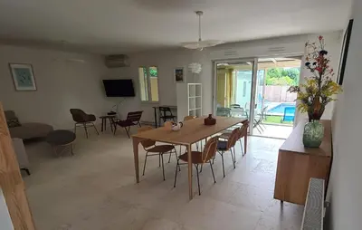 a dining room and living room with a table and chairs at 140 m2 villa with pool in Pernes-Les-Fontaines in Pernes-les-Fontaines