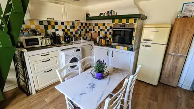 a kitchen with a table and chairs and a refrigerator at Lovely Apartment with a Rooftop View in Aix in Aix-en-Provence