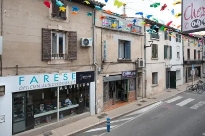 a city street with buildings and shops on a street at Studio Romarin in La Fare-les-Oliviers