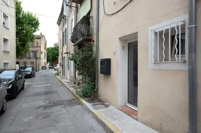 a narrow street with cars parked on the side of a building at Studio Romarin in La Fare-les-Oliviers