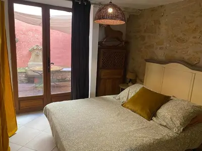 a bedroom with a bed and a large window at appartement de charme in Lançon-Provence