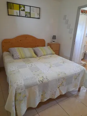 a bedroom with a bed with a quilt on it at Chambres d'Hôtes Chez Cécile à Lagnes in Lagnes