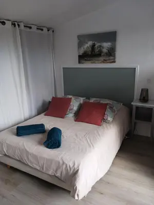 a bed with red and blue pillows in a bedroom at MAISON Terrasse PISCINE in Cavaillon