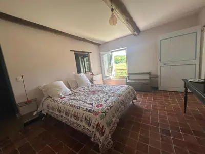 a bedroom with a bed with a quilt on it at Silence et Reconnexion in Mormoiron