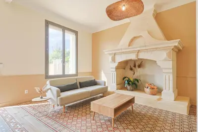 a living room with a couch and a fireplace at Le Champ des Cigales in Noves