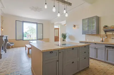 a large kitchen with a large island in the middle at Le Champ des Cigales in Noves