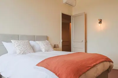 a bedroom with a large white bed with pillows at Le Champ des Cigales in Noves