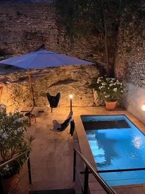 a swimming pool with an umbrella and a table and chairs at Maison de village en Provence Luberon in Saint-Saturnin-les-Apt