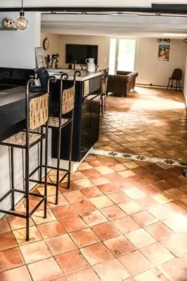 a living room with a tile floor and a bar at Maison provençale avec piscine et vue in Viens