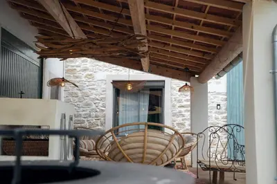 a patio with a table and chairs under awning at La Maison PP une Parenthèse Provençale in Carpentras