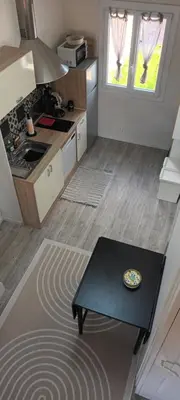 a small kitchen with a table in a room at Nid douillet au cœur du Vaucluse in Entraigues-sur-la-Sorgue