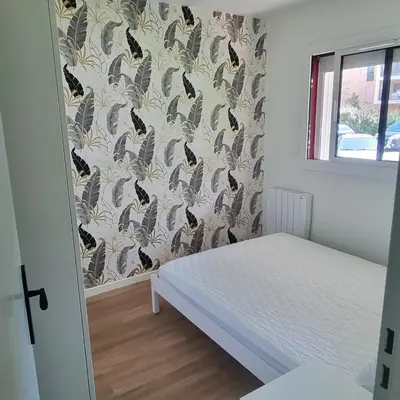 a bedroom with a bed and a wallpaper with birds at Appartement in Aix-en-Provence