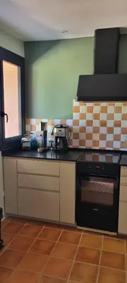 a kitchen with a black stove top oven next to a window at La BERGERIE in Pélissanne