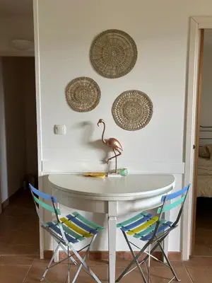 a table with two chairs and a pink flamingo on a wall at Superbe appartement dans golf 4 étoiles in Saumane-de-Vaucluse