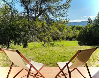 two chairs sitting on a patio with a view of a field at Superbe appartement dans golf 4 étoiles in Saumane-de-Vaucluse