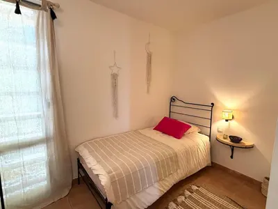 a bedroom with a bed with a red pillow on it at Superbe appartement dans golf 4 étoiles in Saumane-de-Vaucluse