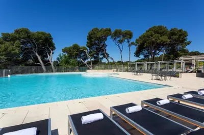 a large swimming pool with lounge chairs and trees at Superbe appartement dans golf 4 étoiles in Saumane-de-Vaucluse