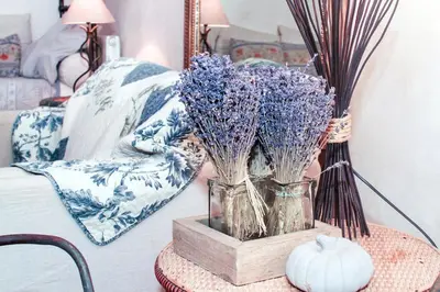 a table with a vase of flowers on a bed at Authentique Bergerie Coeur Luberon in Lacoste