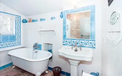 a blue and white bathroom with a tub and sink at Authentique Bergerie Coeur Luberon in Lacoste