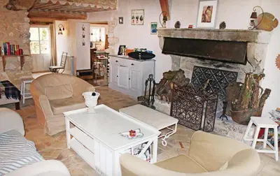 a living room with a fireplace and a table at Authentique Bergerie Coeur Luberon in Lacoste