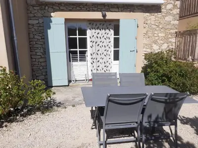 a table and chairs sitting in front of a door at Petit gîte et Grande piscine in Blauvac