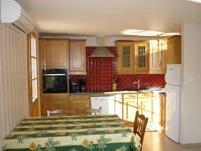 a kitchen with a table and a kitchen with wooden cabinets at Gite PROVENCE MONT VENTOUX in Malemort-du-Comtat