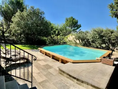 a large swimming pool in a yard with a staircase at Gite PROVENCE MONT VENTOUX in Malemort-du-Comtat