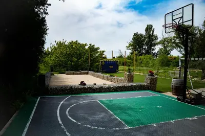 a basketball hoop in a park with a green court at La Maison PP - Appartements in Carpentras