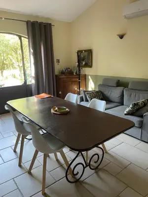 a living room with a table and a couch at Le Bois De La Cour in Roussillon