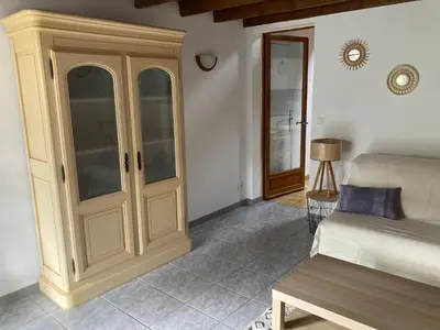 a living room with a cabinet and a bed at Les Vignes in Maubec