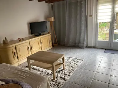 a living room with a tv and a table at Les Vignes in Maubec