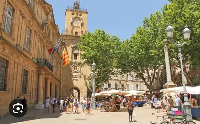 a group of people walking on a city street with a clock tower at New! Le zola studio lumineux en centre ville in Aix-en-Provence