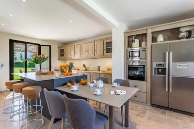 a kitchen with a table and chairs and a refrigerator at Villa Kiki 4 chambres Climatisée Ménerbes in Ménerbes