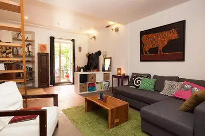 a living room with a couch and a table at Maison dans un coin de verdure proche de la Sorgue in LʼIsle-sur-la-Sorgue