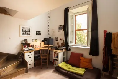a room with a desk with a computer and a couch at Maison dans un coin de verdure proche de la Sorgue in LʼIsle-sur-la-Sorgue