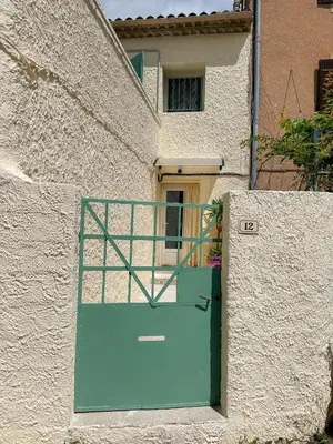 a building with a green door in front of it at Cosy Cœur Alpilles, T2 neuf in Aureille