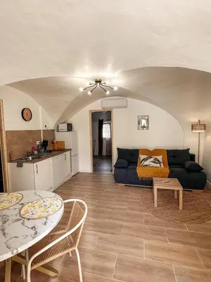 a living room with a couch and a table at Cosy Cœur Alpilles, T2 neuf in Aureille