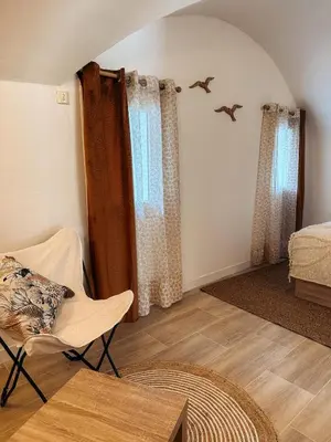 a living room with a chair and a bed at Cosy Cœur Alpilles, T2 neuf in Aureille
