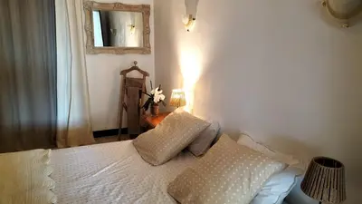 a bedroom with a bed with a lamp and a mirror at Escale vélo La petite Reine in Cavaillon