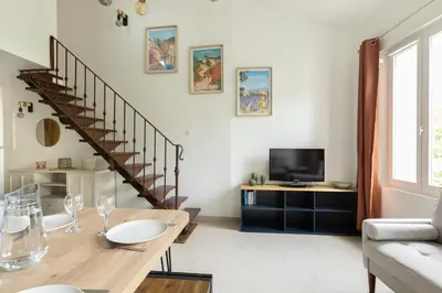 a living room with a table and a staircase at Le Duplex des Ocres - 2 bedrooms - Air conditioning - WiFi in Apt