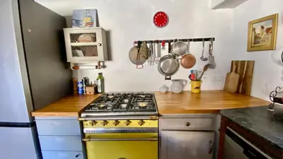 a shelf filled with pots and pans and bowls at La Mistraline, in the center of the Luberon, Provence 2 bedroom, 2 bath Village House in Caseneuve