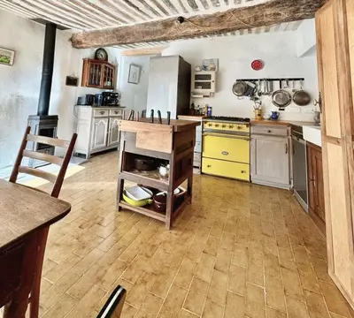 a kitchen with a refrigerator and a counter with pots and pans at La Mistraline, in the center of the Luberon, Provence 2 bedroom, 2 bath Village House in Caseneuve