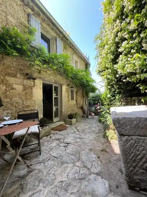 a stone house with a table in front of it at Chez Marthe - Maison de village - Ménerbes centre in Ménerbes
