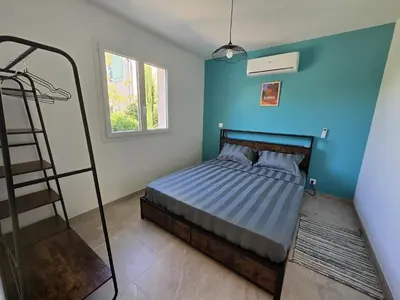 a bedroom with a bed with a blue wall at Cocoon Luberon in Lauris