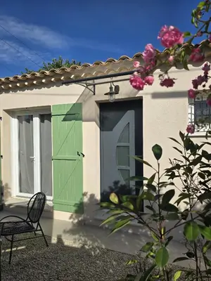 a house with a green door and a chair at Cocoon Luberon in Lauris