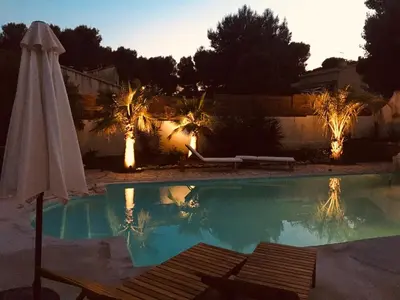 a swimming pool with an umbrella and an umbrella at Provencal villa with pool and large terrace in Rognac