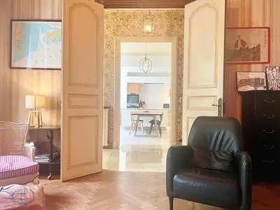 a living room with a chair and a table at Bourgeois House - 16 personnes, Piscine, 6 chambres, 8 lits, 4 SDB, Centre-ville, CLIM in Salon-de-Provence